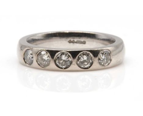 An 18ct white gold diamond set half hoop band ring, or wedding ring. With five brilliant cut diamonds, gypsy set to a plain b