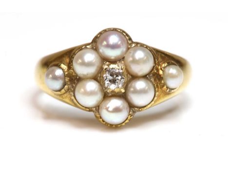A late Victorian diamond and split pearl cluster ring, c.1900,with an old European cut diamond set to the centre. A border of