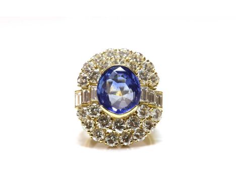 A two row sapphire and diamond oval cluster ring,with an oval mixed cut sapphire, end set to the centre. A border comprised o