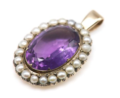 A late Victorian amethyst and seed pearl pendant,with an oval mixed cut amethyst, claw set to the centre. A border of seed pe