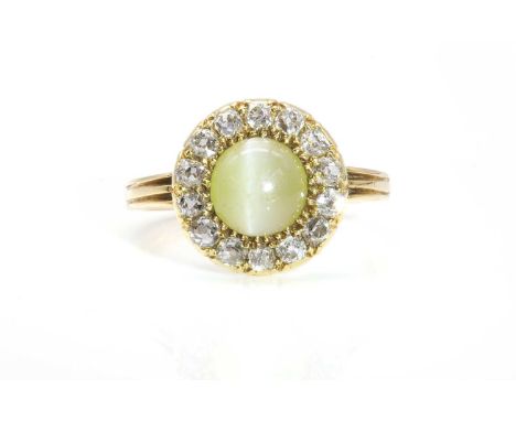 A late Victorian chrysoberyl and diamond circular cluster ring,with a circular cabochon chrysoberyl, claw set to a border of 