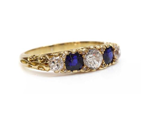 A five stone diamond and sapphire carved head style ring,with an old European cut diamond, claw set to the centre. A circular