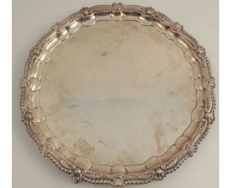 A silver salver, with gadrooned and shell shaped edge, raised on four ball and claw feet, Sheffield 1960, weight 63oz