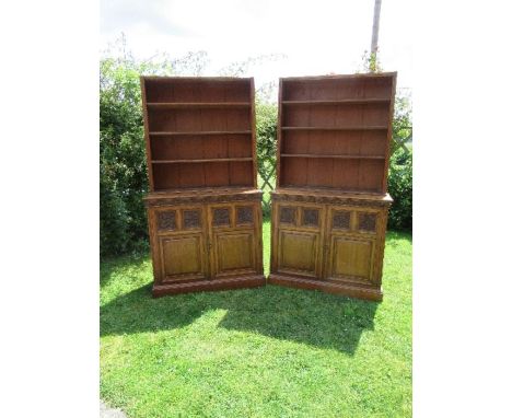 A pair of late 19th century oak bookcases, fitted open shelves to the upper section, and a further shelf below two part carve