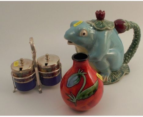 A Poole pottery vase, decorated with flowers to a red ground, together with a modern majolica frog tea pot and a condiment se