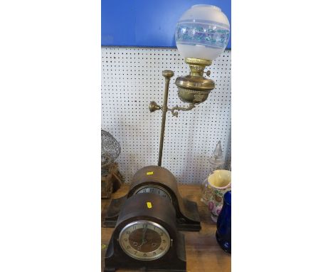 A brass oil lamp, with telescopic stand, having a glass shade, converted to electricity, together with two oak cased mantel c