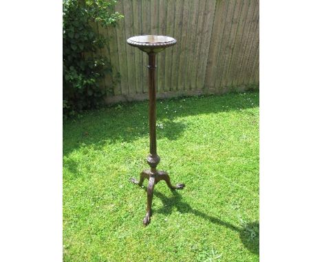 A mahogany torchere, having a reeded column, raised on a tripod base, terminating in claw on ball feet, diameter 9ins, height