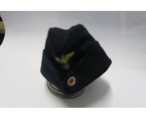 A Third Reich style M38 side hat, in black wool, having appliqued yellow RMBO motif to the front, above an appliqued cockade,