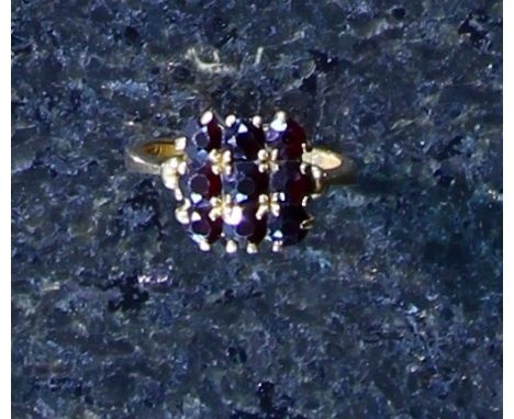 An antique garnet ring in yellow gold, the nine round cut garnets claw set into a square grid pattern. Size O / 7. Gross Weig