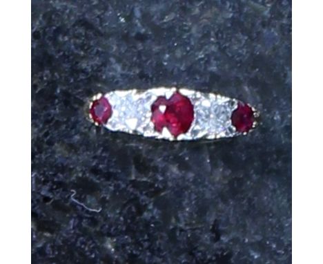 An antique Victorian ruby and diamond five stone ring in high carat yellow gold, The central old cut ruby set between two sma