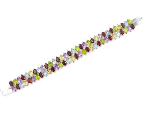 A garnet, peridot, topaz, citrine and amethyst bracelet, comprising of a double layer of claw set oval cut stones. Length 20c