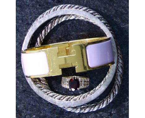 A vintage Hermes enamelled bangle, along with a garnet ring and three silver bangles. Diameter 6cm.