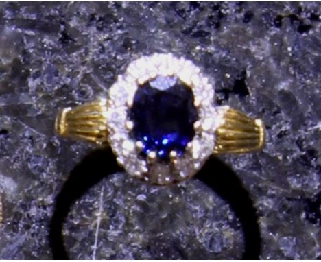 A vintage sapphire and diamond cluster ring in 18ct yellow gold, the central sapphire weighing approximately 1.44ct, surround