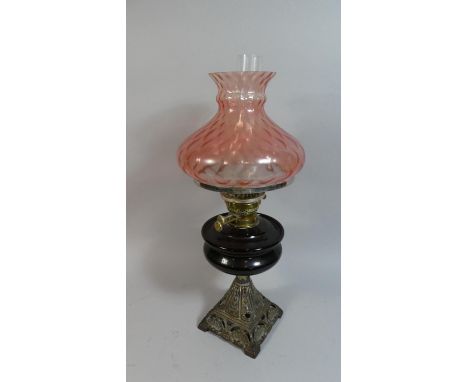 A Late Victorian Iron Based Oil Lamp with Coloured Glass Reservoir and Shade, 56cm high 