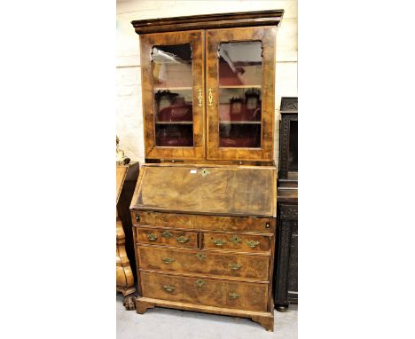 Walnut bureau bookcase, the moulded cornice above two shaped glazed panel doors enclosing shelves, the base with a fall front