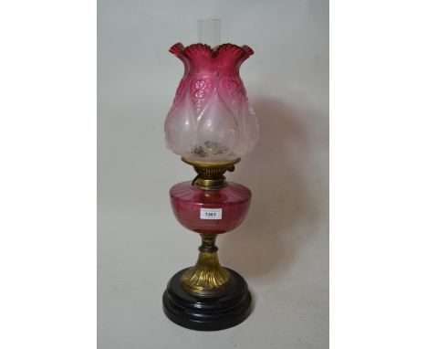 Late 19th / early 20th Century oil lamp having cranberry glass well and an etched cranberry and clear glass shade, 22ins high