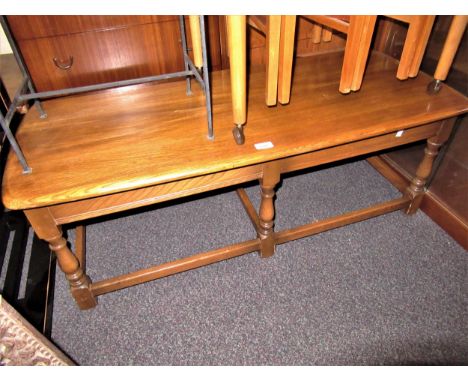 Ercol rectangular light elm coffee table on turned supports with stretchers, 44ins x 19ins x 16ins high 