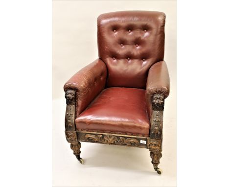 Victorian red button leather upholstered library armchair with carved walnut maskhead arms, above a shell carved frieze and t
