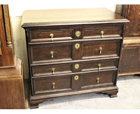 Early 18th Century oak chest, the moulded top above two short and three long moulded drawers with brass drop handles and escu
