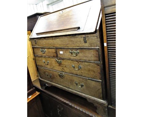18th Century oak bureau, the fall front enclosing a fitted interior above two short and three long drawers with brass handles