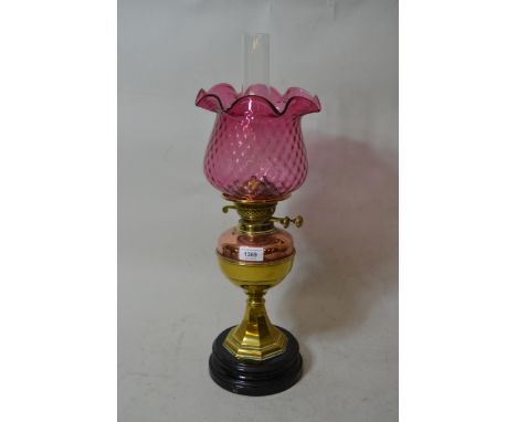Late 19th / early 20th Century brass and copper oil lamp, having cranberry glass shade 