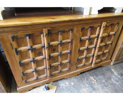 Modern oriental hardwood and iron mounted side cabinet with two pairs of panelled doors on bracket feet, 62ins wide 
