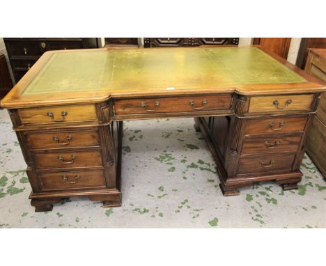 Reproduction mahogany inverted breakfront partner's desk, the green tooled leather inset top above drawers and cupboard doors