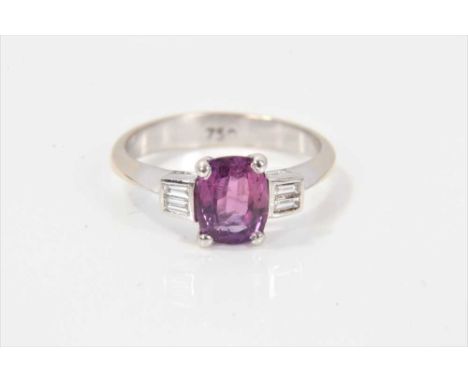 Ruby and diamond ring with an oval mixed cut ruby (probably treated) measuring approximately 7.15mmx 5.55mm flanked by baguet