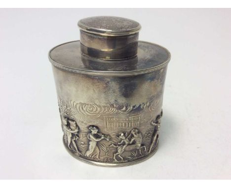 George V silver tea caddy of oval form with embossed decoration depicting Greek Gods in a classical landscape, with reeded bo
