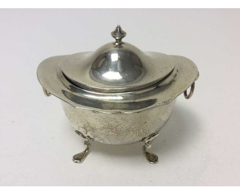 Edwardian silver tea caddy of oval form with twin ring handles, and domed hinged cover, raised on four hoof feet, (Birmingham