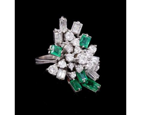 Emerald and diamond cluster cocktail ring with an asymmetrical cluster of brilliant cut an baguette cut diamonds, and rectang