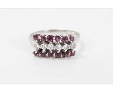 Ruby and diamond three row ring with a row of six brilliant cut diamonds flanked by round mixed cut rubies in claw setting on