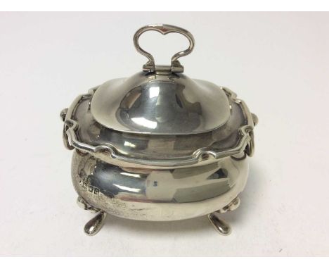 George V silver tea caddy of cauldron form with twin ring handles, hinged cover with folding handle and gilded interior, rais