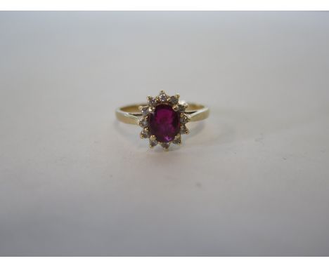 A 14ct gold ruby and diamond ring, ruby 7mm oval, size M, approx 2.7 grams in good condition 