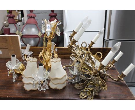 A gilt metal six way light fitting with glass bowls and drops together with a further brass and metal six way light fitting 