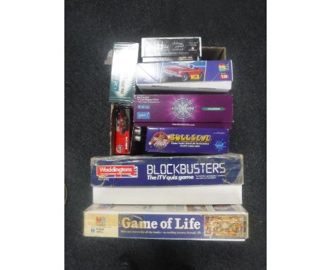 A box of assorted board games, Airfix modelling kits, Jaguar E Type and MG sports car 