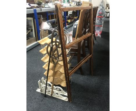 A contemporary wine rack, folding clothes airer, carpet beater, silver handled walking stick, two antique cast iron wall brac