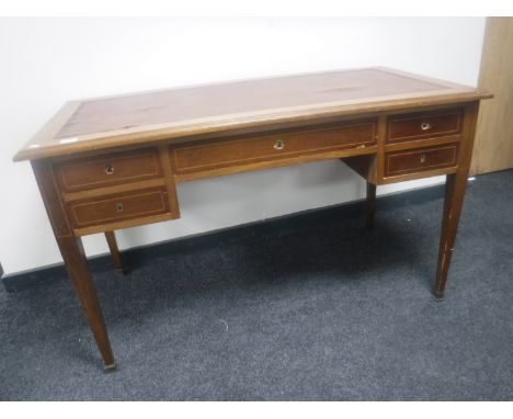 A Victorian inlaid mahogany five drawer writing desk with brown leather inset panel 