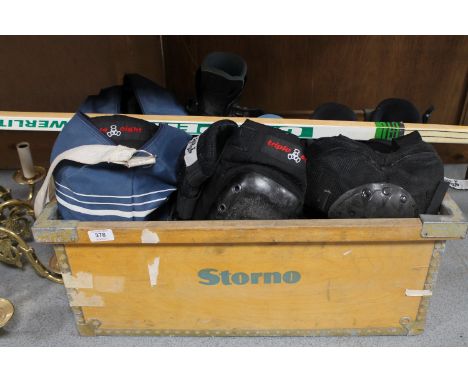 A box of two pairs of inline skates, pair of roller boots in carry bag, street hockey stick together with knee and elbow pads