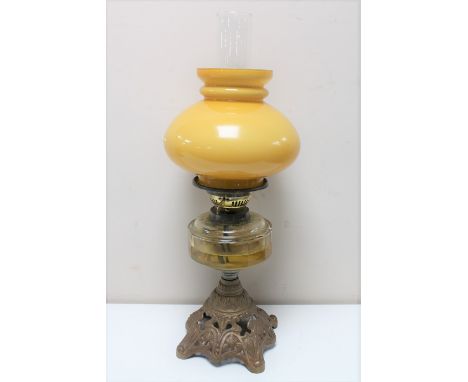 An antique Duplex oil lamp on cast iron base with clear glass reservoir, chimney and shade