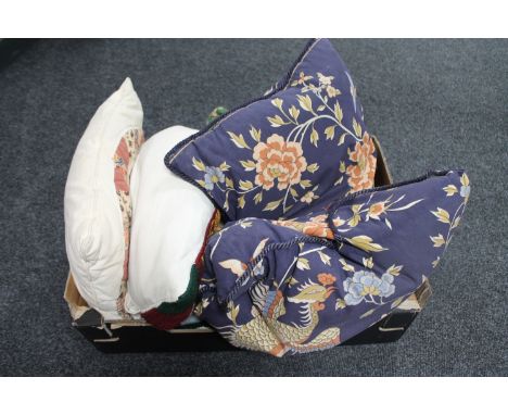 A box containing a tapestry cushion together with two patchwork cushions and two further blue floral cushions