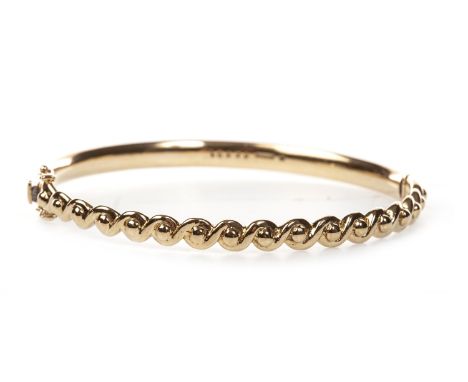 NINE CARAT GOLD BANGLE, of oval form, with looping decoration, 63mm wide, 17.5g