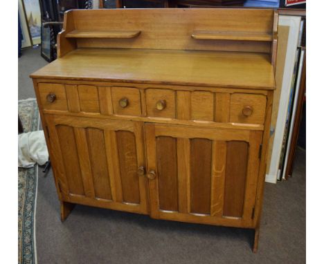 Arts &amp; Crafts light oak Cotswold School sideboard fitted with two open shelves over two panelled drawers and two cupboard