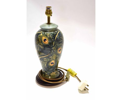 Modern Moorcroft lamp base with a peacock feather style design tube lined in green seated on a circular wooden base, lamp 30c
