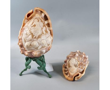 Two carved cameo shells, one on stand, one depicting portrait of a woman the other with cherubs.  (2)  (B.P. 21% + VAT) 