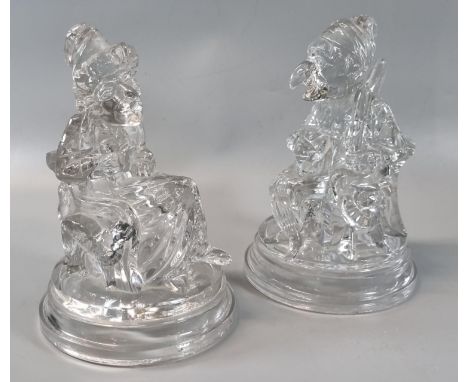 Pair of hollow clear moulded glass figures: 'Punch and Judy', on circular step bases with moulded anchor marks to the inset. 