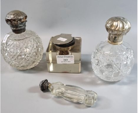 Two similar cut glass globular scent bottles with silver lids together with another Edwardian design scent bottle and a silve