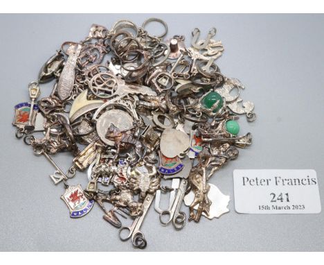 A collection of silver and white metal charms including enamel, 'Wales' charm, scissors, skateboard etc.  Approx weight 4.53o