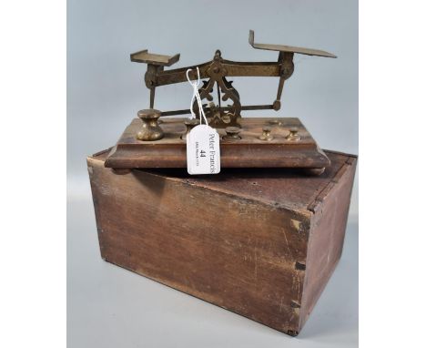 Set of brass letter scales with graduated brass weights on a moulded wooden base with appearing original pine box. 20cm wide 
