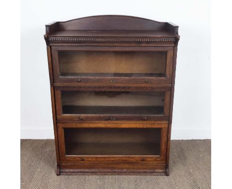 THE LEBUS BOOKCASE, Edwardian oak in sections of three glazed doors, 124cm H x 88cm W x 36cm D.